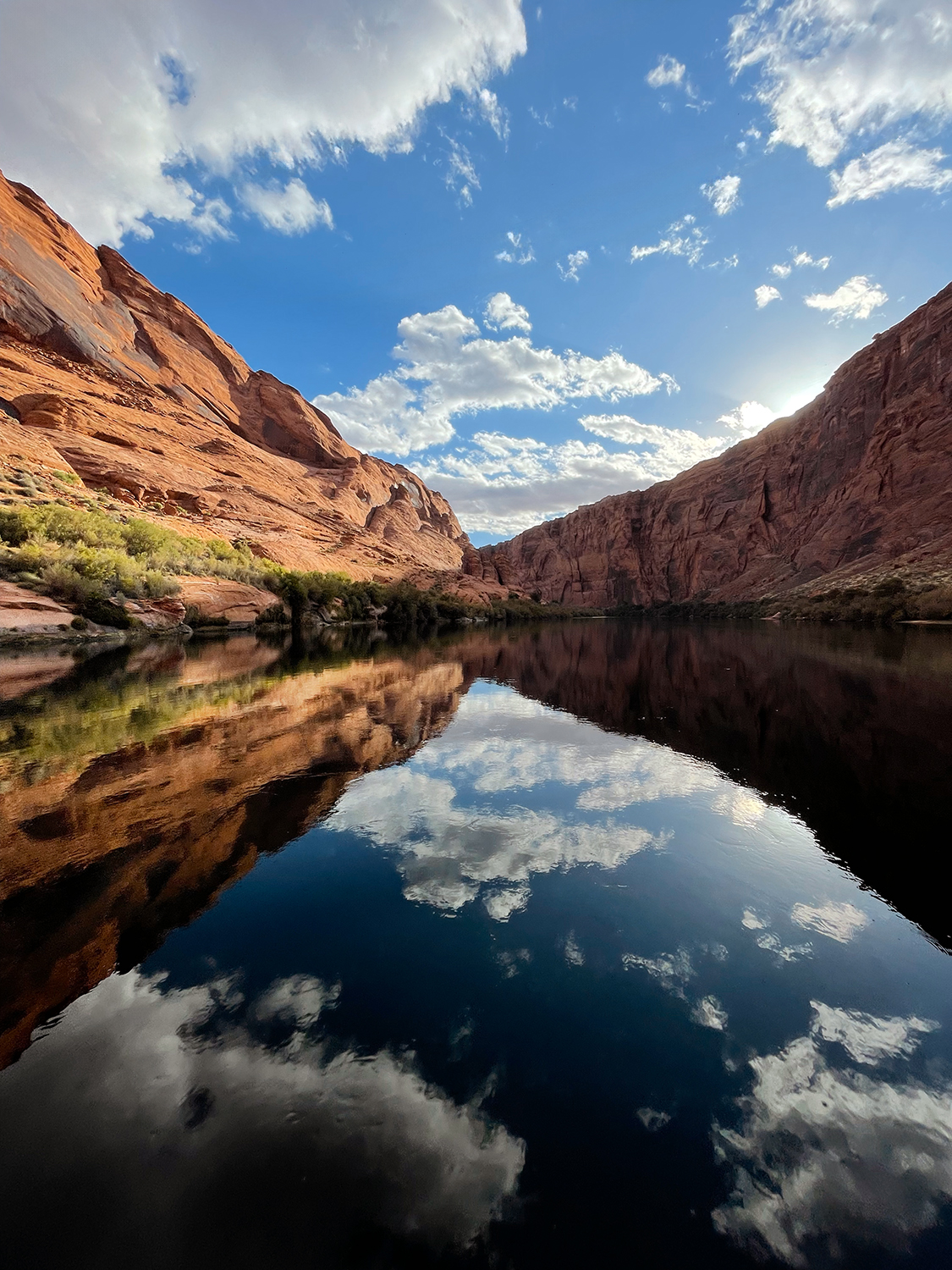 Reflections of cliffs and clouds in the Colorado River in Glen Canyon, AZ